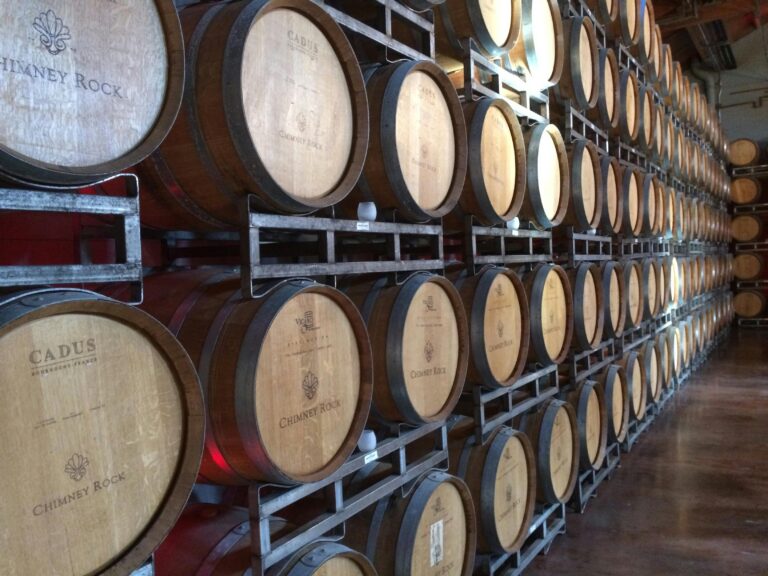 Wooden wine barrels in a Napa, CA winery, ideal for wine production visuals.